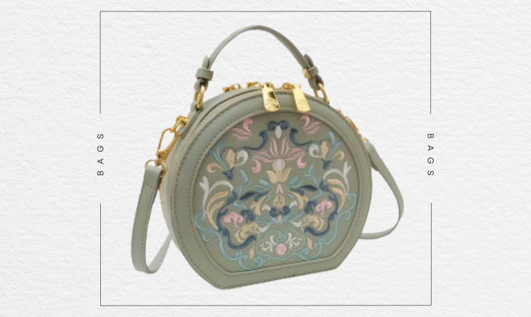 Green crossbody bag with floral embroidery on a white background, featuring 'The Sunday Club' branding.