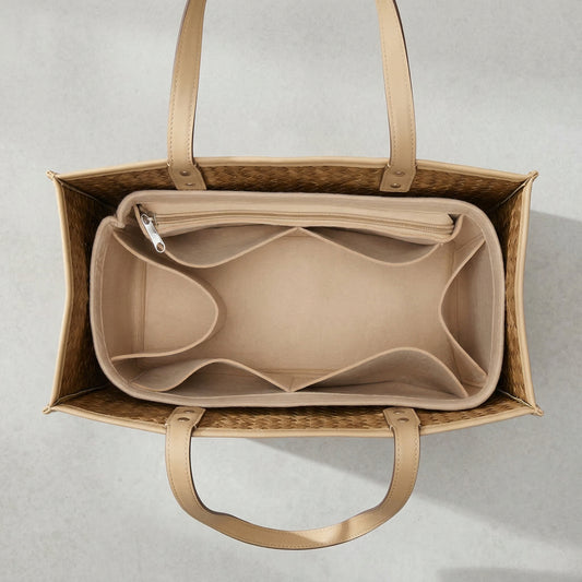 Beige handbag with interior compartments on a light gray background